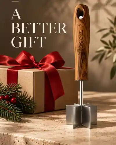 A wood-handled masher beside a gift box with a red ribbon